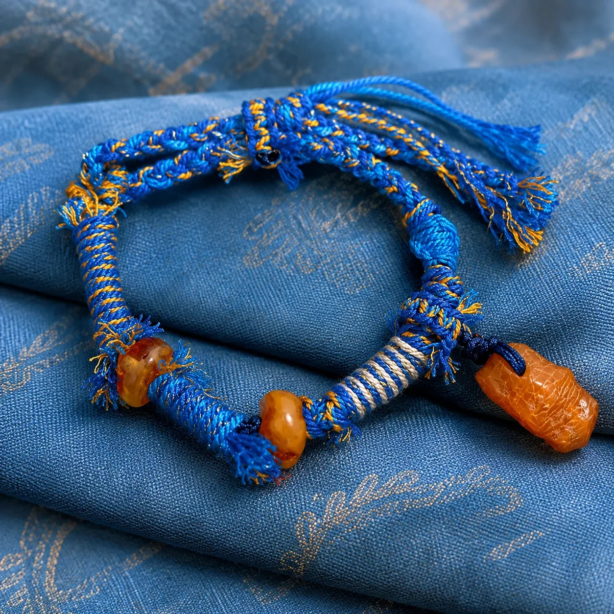 Natural amber beads on a contemporary Kailora Tibetan-inspired woven cord bracelet