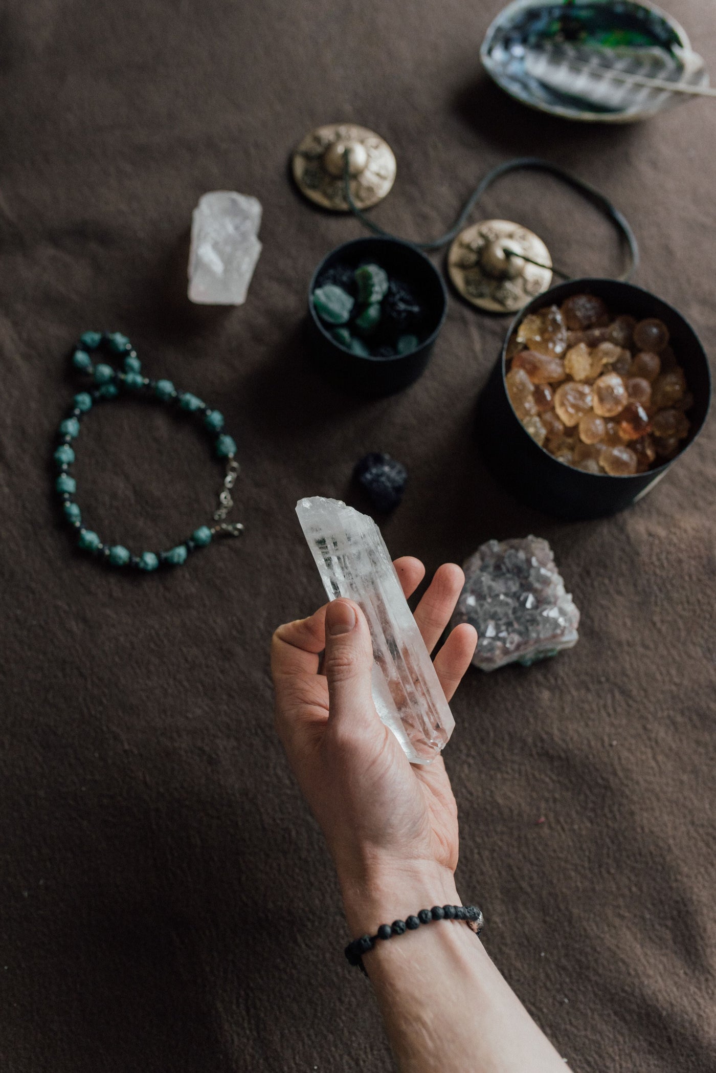 A hand holding clear quartz for a guide to setting an intention with crystals