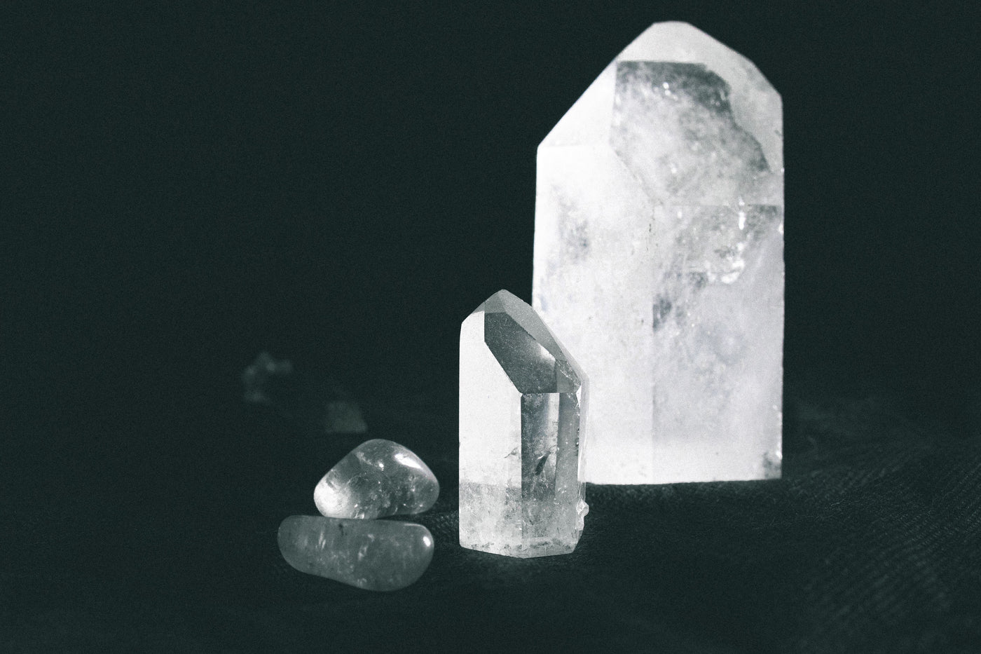 Assorted natural quartz crystals on a dark surface for choosing crystals by personal intention