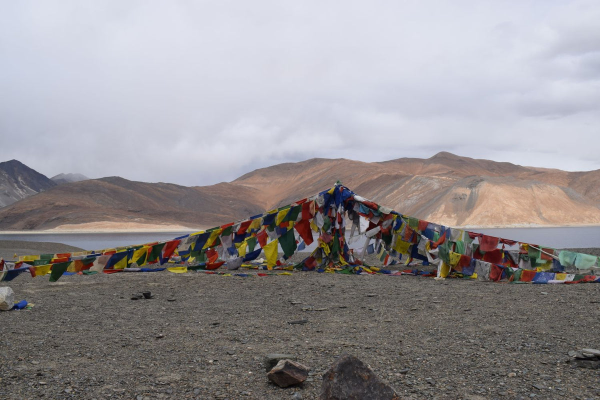Tibetan prayer flags beside a Himalayan lake in Tibet