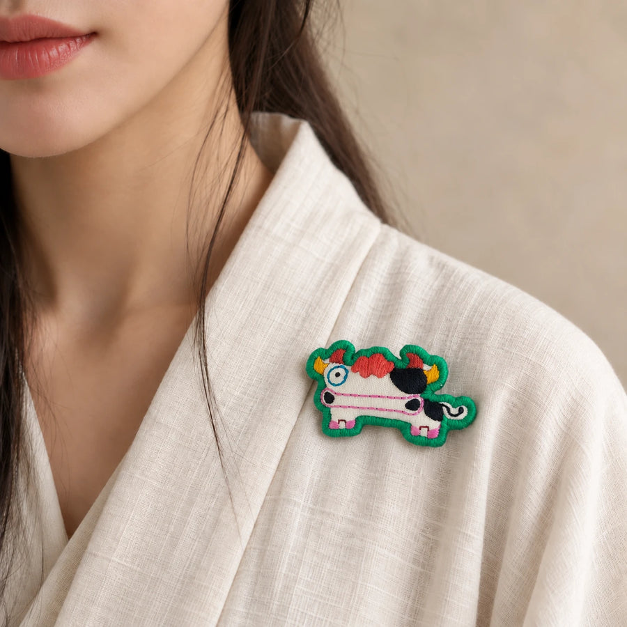 Model wearing Chou Ox Chinese Zodiac hand-embroidered cotton-linen brooch handcrafted in Tibet detail view 23 | Kailora