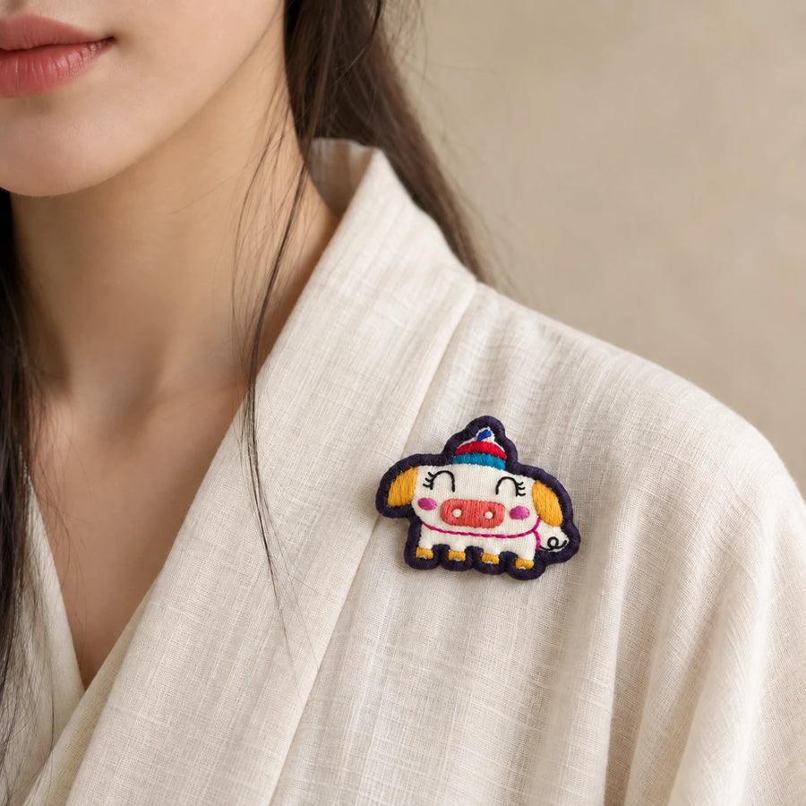 Model wearing Hai Pig Chinese Zodiac hand-embroidered cotton-linen brooch handcrafted in Tibet detail view 33 | Kailora