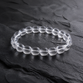 Kailora Himalayan Clarity handcrafted natural clear quartz bracelet on dark stone thumbnail 1 | Kailora