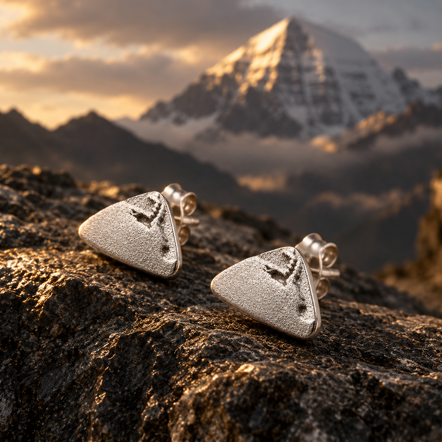 Mount Kailash-inspired silver-tone stud earrings on Himalayan rock detail view 1 | Kailora