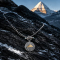 Mount Kailash pendant necklace resting on dark Himalayan rock with snow details thumbnail 3 | Kailora
