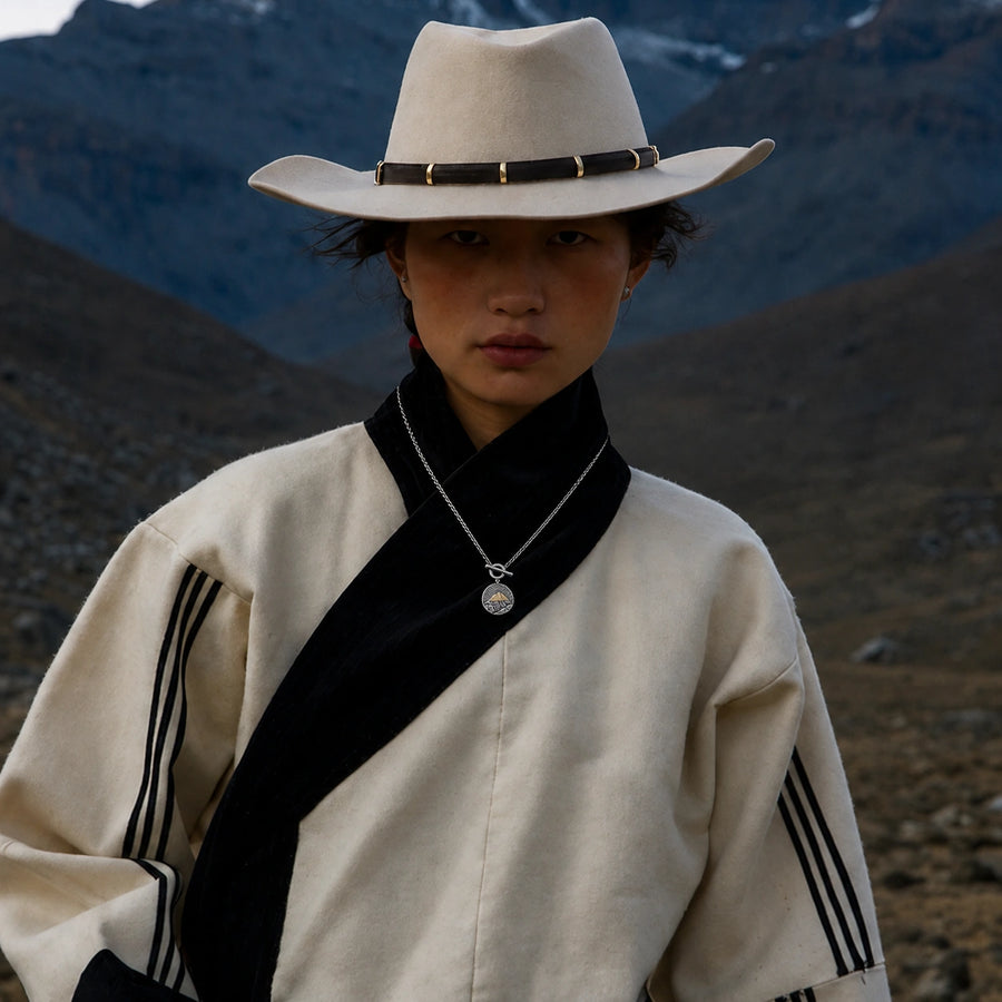 Kailora Mount Kailash pendant necklace styled with black and ivory Tibetan-inspired clothing detail view 5 | Kailora