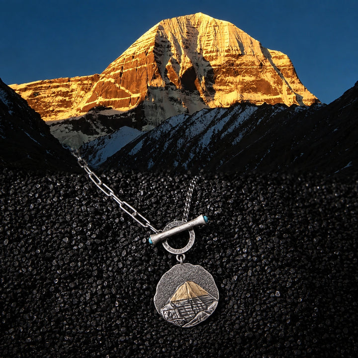 Mount Kailash pendant necklace on black rock with Mount Kailash at golden hour