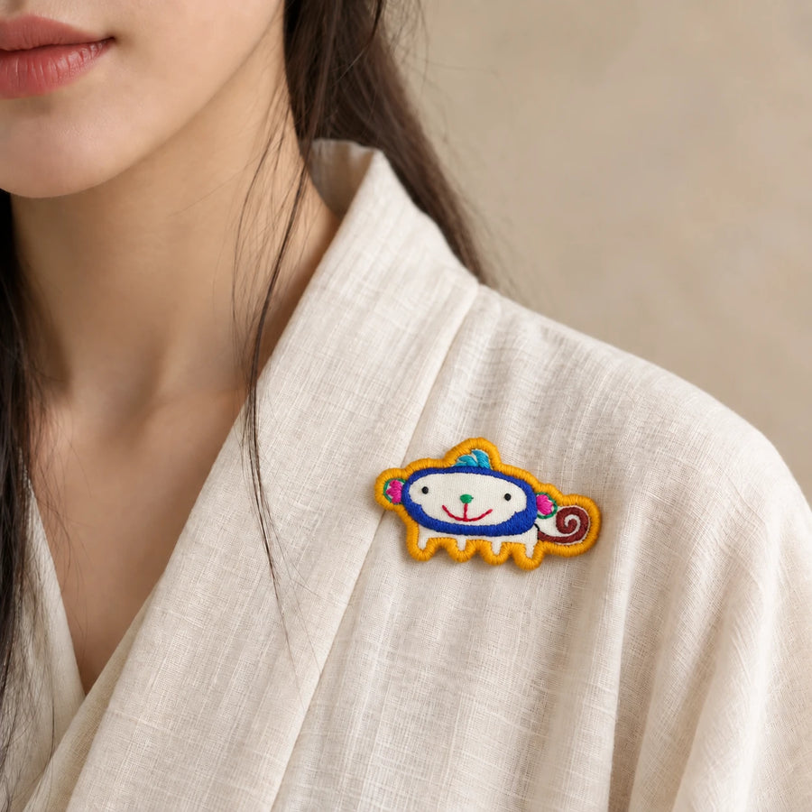 Model wearing Shen Monkey Chinese Zodiac hand-embroidered cotton-linen brooch handcrafted in Tibet detail view 30 | Kailora