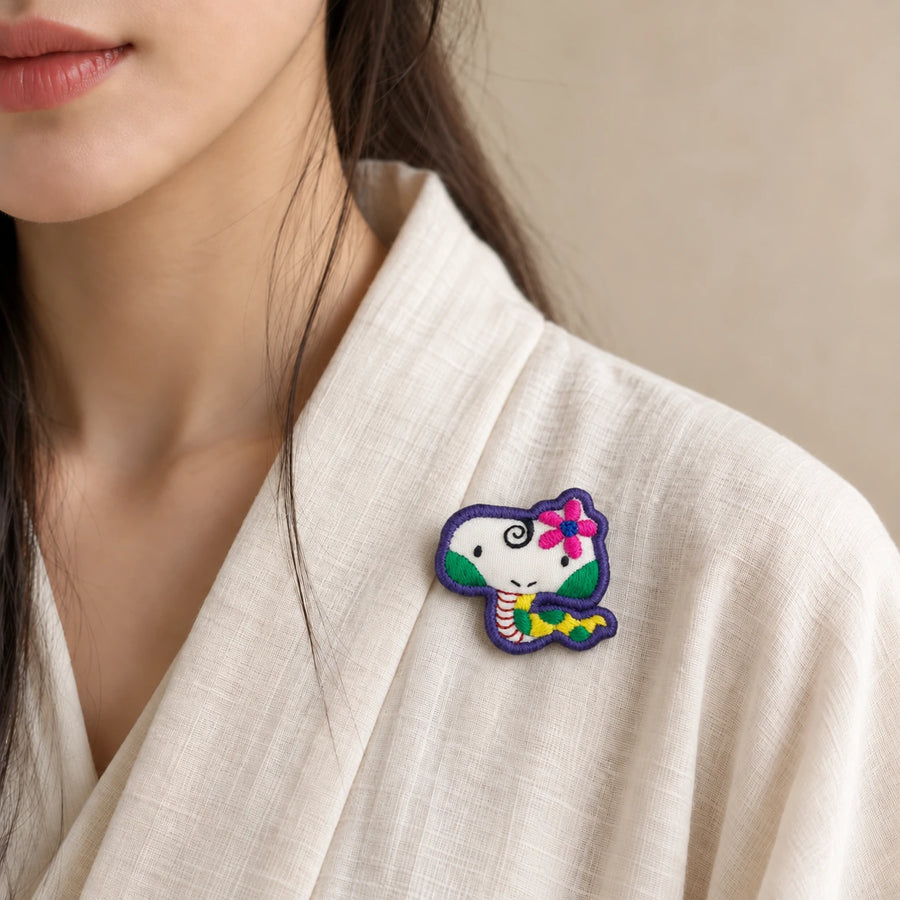 Model wearing Si Snake Chinese Zodiac hand-embroidered cotton-linen brooch handcrafted in Tibet detail view 27 | Kailora