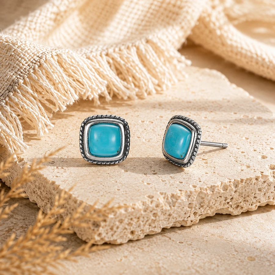 Kailora Tibetan turquoise stud earrings shown at a 45 degree angle on warm stone detail view 5 | Kailora