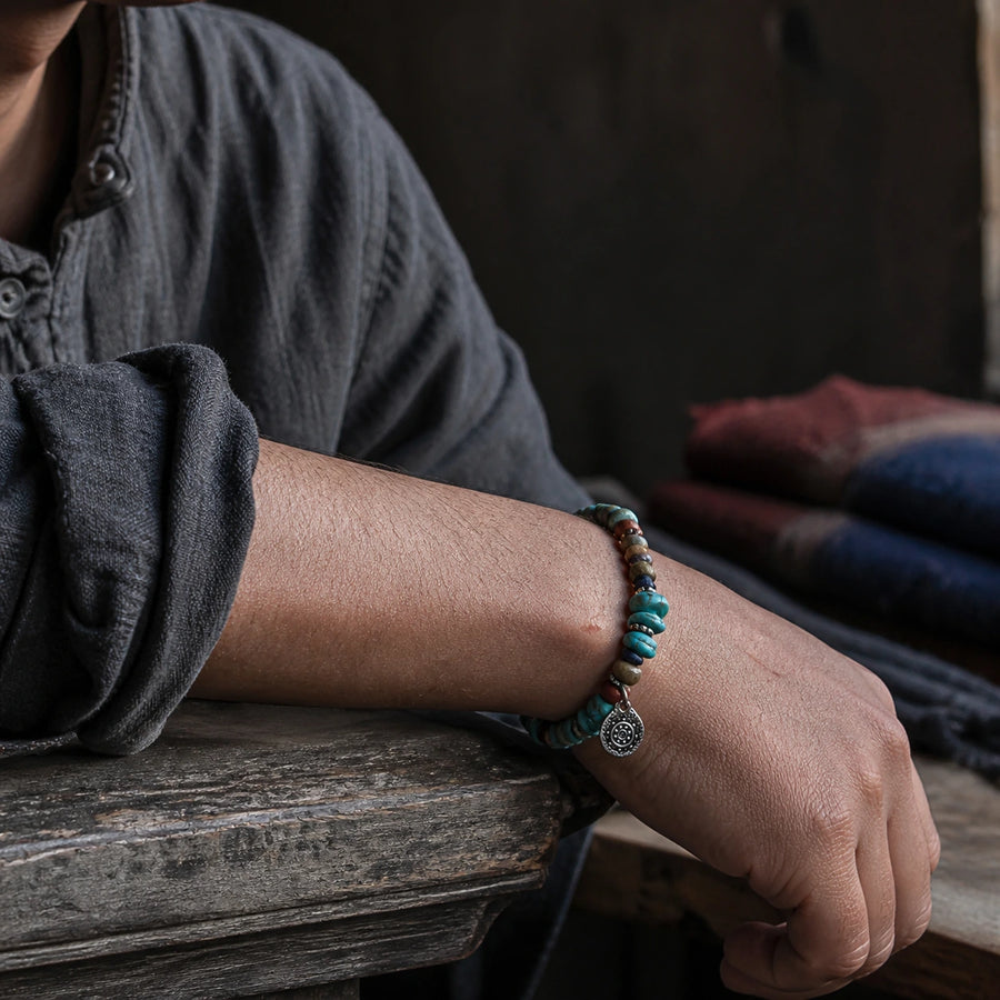 Close-up wrist wearing turquoise and mixed stone stretch bracelet with silver-toned charm detail view 5 | Kailora