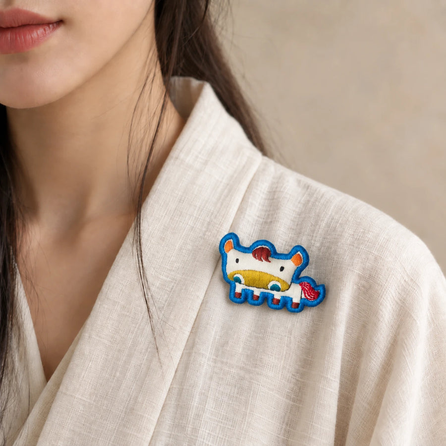 Model wearing Wu Horse Chinese Zodiac hand-embroidered cotton-linen brooch handcrafted in Tibet detail view 28 | Kailora