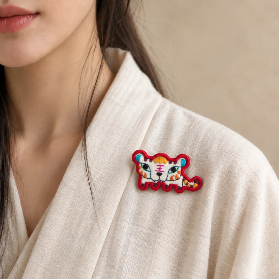 Model wearing Yin Tiger Chinese Zodiac hand-embroidered cotton-linen brooch handcrafted in Tibet detail view 24 | Kailora