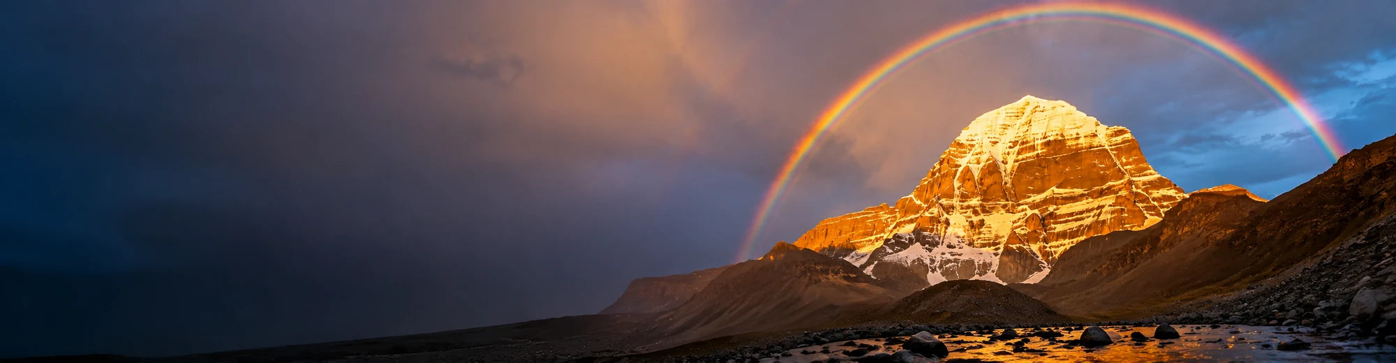 Mount Kailash beneath a rainbow at golden hour